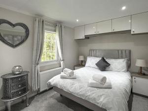 a bedroom with a bed with two towels on it at Sunset Lodge in Warkworth