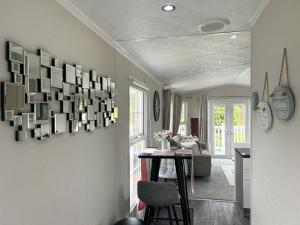 a living room with a table and some pictures on the wall at Sunset Lodge in Warkworth