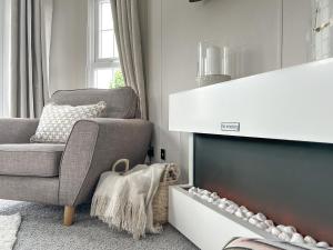a living room with a chair and a fireplace at Sunset Lodge in Warkworth +4 photos