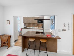 a kitchen with a island with two bar stools at Rooftops No83 in St. Leonards