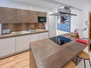 a kitchen with white cabinets and a counter top at Rooftops No83 in St. Leonards