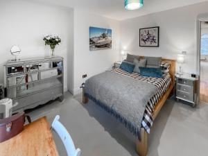 a bedroom with a bed with blue pillows and a dresser at Rooftops No83 in St. Leonards +3 photos