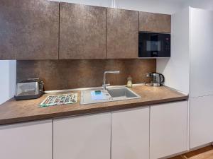 a kitchen with a sink and a microwave at Rooftops No83 in St. Leonards
