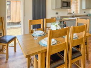 a wooden dining room table with chairs and a kitchen at Lodge 3 - Uk51092 in Perranporth