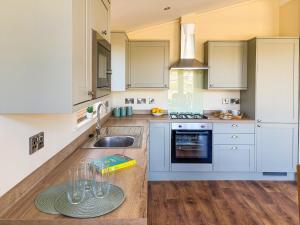 a kitchen with white cabinets and a sink at Lodge 3 - Uk51092 in Perranporth