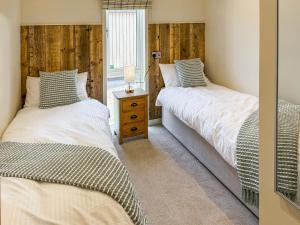 two twin beds in a room with a window at Lodge 3 - Uk51092 in Perranporth +6 photos