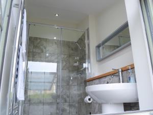 a bathroom with a sink and a glass shower at The Fish House in Rispond