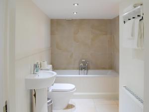 a bathroom with a sink and a toilet and a tub at The Fish House in Rispond +14 photos