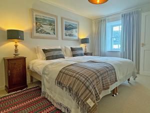 a bedroom with a bed and two lamps and a window at The Cottage in Rispond