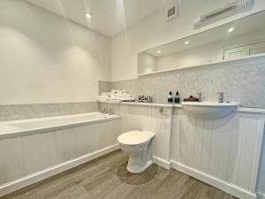 a white bathroom with a toilet and a sink at The Cottage in Rispond