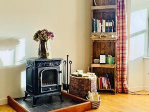 a black stove in a room with a book shelf at The Cottage in Rispond +13 photos