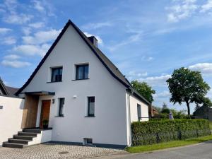 a white house with a black roof at Ferienhaus L45 in Elsterheide