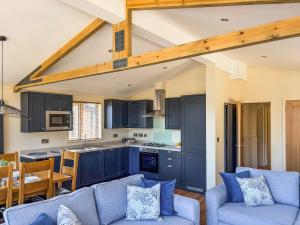 a living room with blue couches and a kitchen at Lodge 4 - Uk51095 in Perranporth