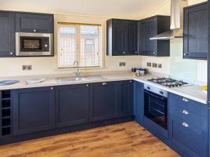 a kitchen with blue cabinets and a sink at Lodge 4 - Uk51095 in Perranporth