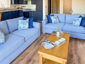 a living room with two blue couches and a table at Lodge 4 - Uk51095 in Perranporth