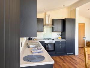 a kitchen with black cabinets and a sink at Lodge 4 - Uk51095 in Perranporth