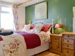 a bedroom with a bed and a dresser and a window at Reed Lodge in Littleport