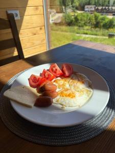 a plate of food with eggs and tomatoes on a table at Готель White House in Yablunytsya +85 photos