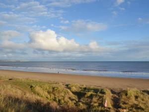 a woman standing on a beach with the ocean at Number 150 in Bessingby