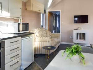 a kitchen and living room with a couch and a microwave at Number 150 in Bessingby +6 photos