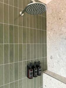 a shower with four bottles on a shelf in a bathroom at Tourist Hotel Queanbeyan in Queanbeyan