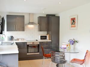 a kitchen with a glass table and chairs in it at Happys in St Ives