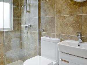 a bathroom with a shower and a toilet and a sink at Happys in St Ives