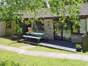 a cabin with a picnic table and a bench at Happys in St Ives