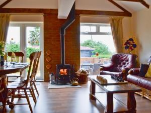 a living room with a fireplace and a table at Sedge Lodge in Littleport