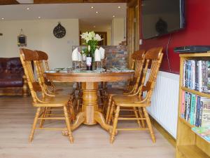 a dining room table with four chairs and a bottle of wine at Sedge Lodge in Littleport