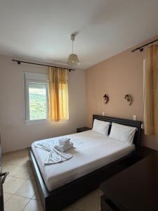 a bedroom with a large white bed with a window at Hotel Iliana in Mandrotopos