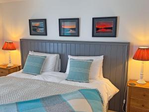 a bedroom with a bed with two lamps and two pillows at The Byre in Rispond