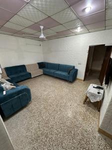 a living room with blue couches in a room at Welcoming Multi-Bedroom House in Duhok