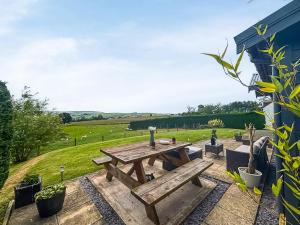 a picnic table on a patio with a view of a field at Poundgate Lodge in Knighton