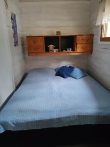 a bedroom with a blue bed in a room at Metsämökki in Lohja