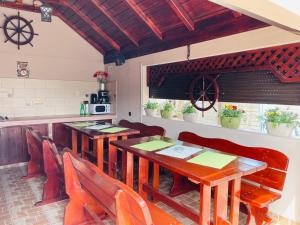 a dining room with wooden tables and chairs at Vila Bya in 2 Mai