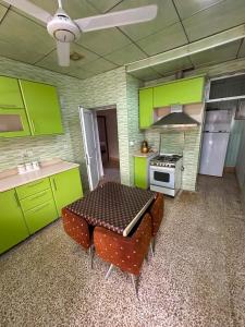 a kitchen with green cabinets and a table with chairs at Welcoming Multi-Bedroom House in Duhok