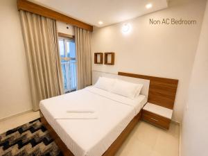 a small bedroom with a bed with a window at Mirage 8D Inn in Vythiri +12 photos