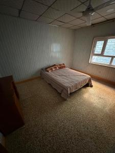 a bedroom with a bed in a room with a window at Welcoming Multi-Bedroom House in Duhok