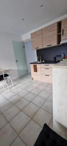 a kitchen with a white tiled floor and wooden cabinets at Studio moderne Évian, lac et therme in Évian-les-Bains +7 photos