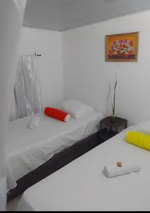 a bedroom with a bed with a red pillow on it at Apart Cabaña KTIK in San Bernardo del Viento
