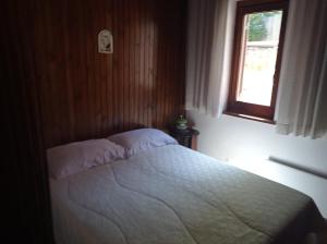 a bedroom with a bed and a window at Montanara Home in Camigliatello Silano