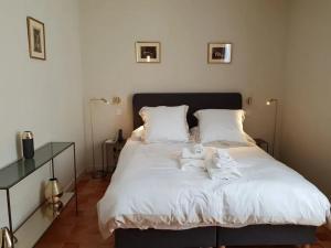 a bedroom with a bed with white sheets and pillows at La Villa Saint-Antoine in Violès