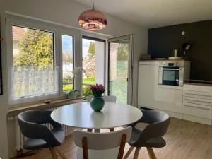 a dining room with a table and chairs and a kitchen at Ferienhaus L45 in Elsterheide