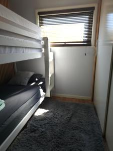 a bedroom with two bunk beds and a window at The Lucky 7 in Hemsby