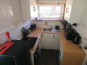 a small kitchen with a sink and a black refrigerator at The Lucky 7 in Hemsby