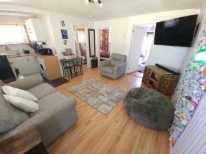 a living room with a couch and a chair at The Lucky 7 in Hemsby