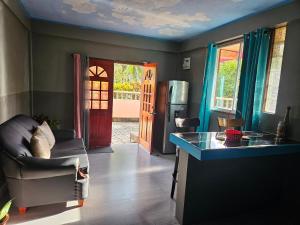 a living room with a kitchen with a couch and a refrigerator at The Jungle Escape Apartment 01 in Malgretoute