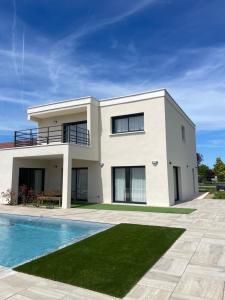 a white house with a swimming pool in front of it at Villa 220 m2 avec 5 chambres 6 lits doubles 2 toilettes 2 salles de bain in Beire-le-Châtel