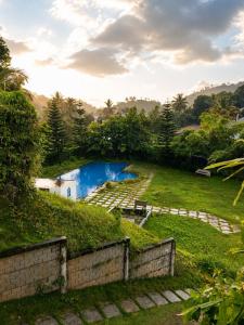 a swimming pool in a park with a grassy field at Mirage 8D Inn in Vythiri